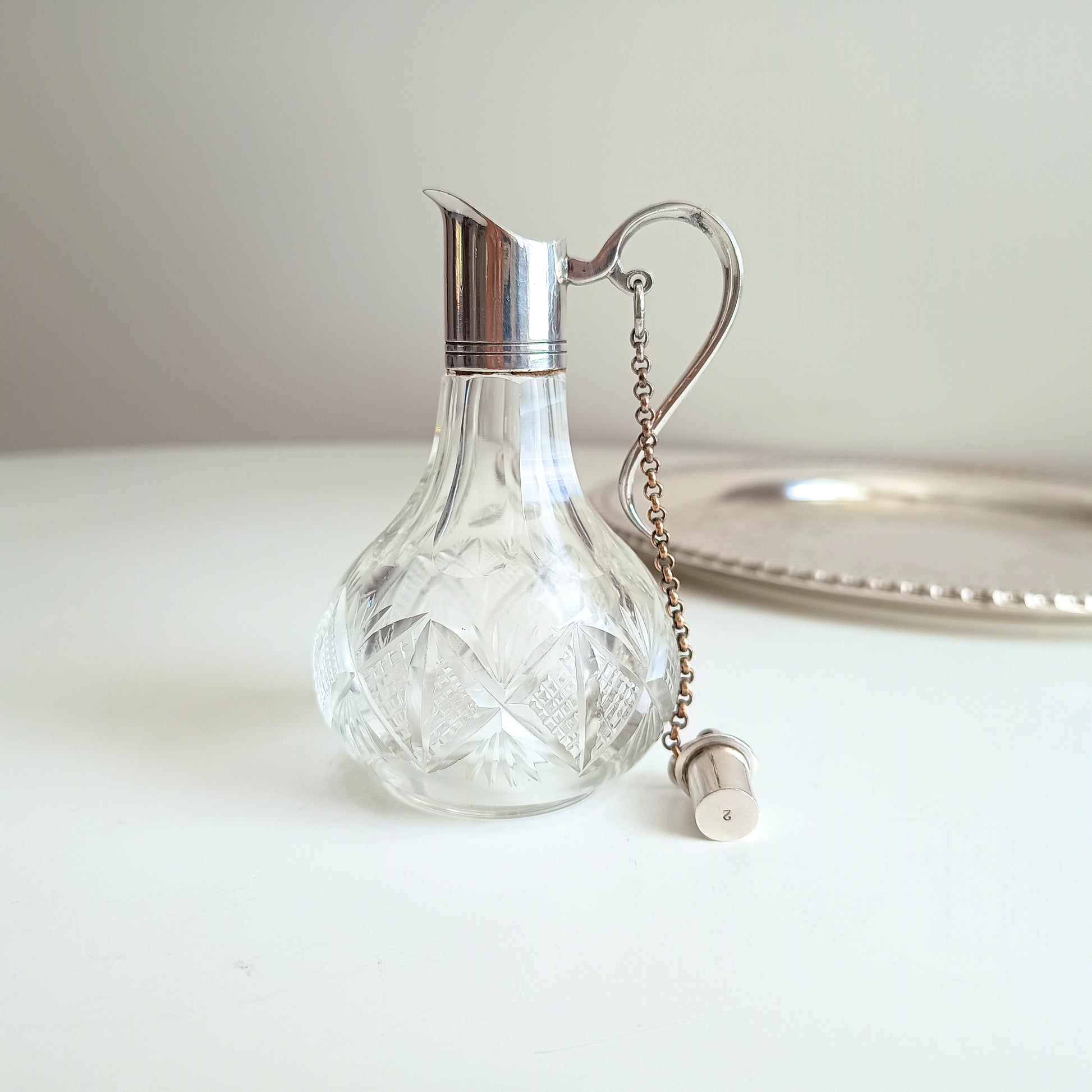 Cut glass small carafe with silver lid and chain and stopper