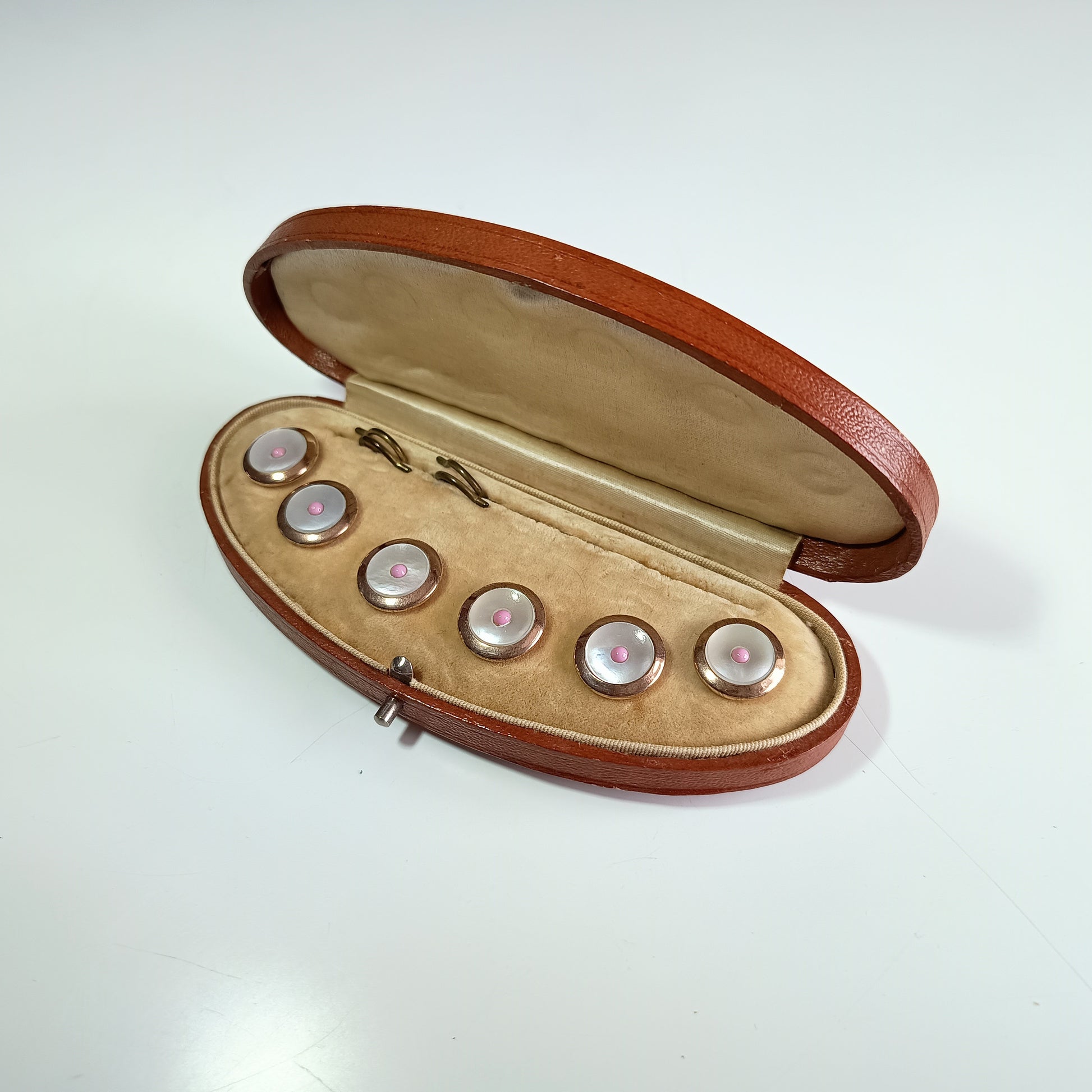 Open brown leather case with six round silver gilt buttons with cream velvet interior