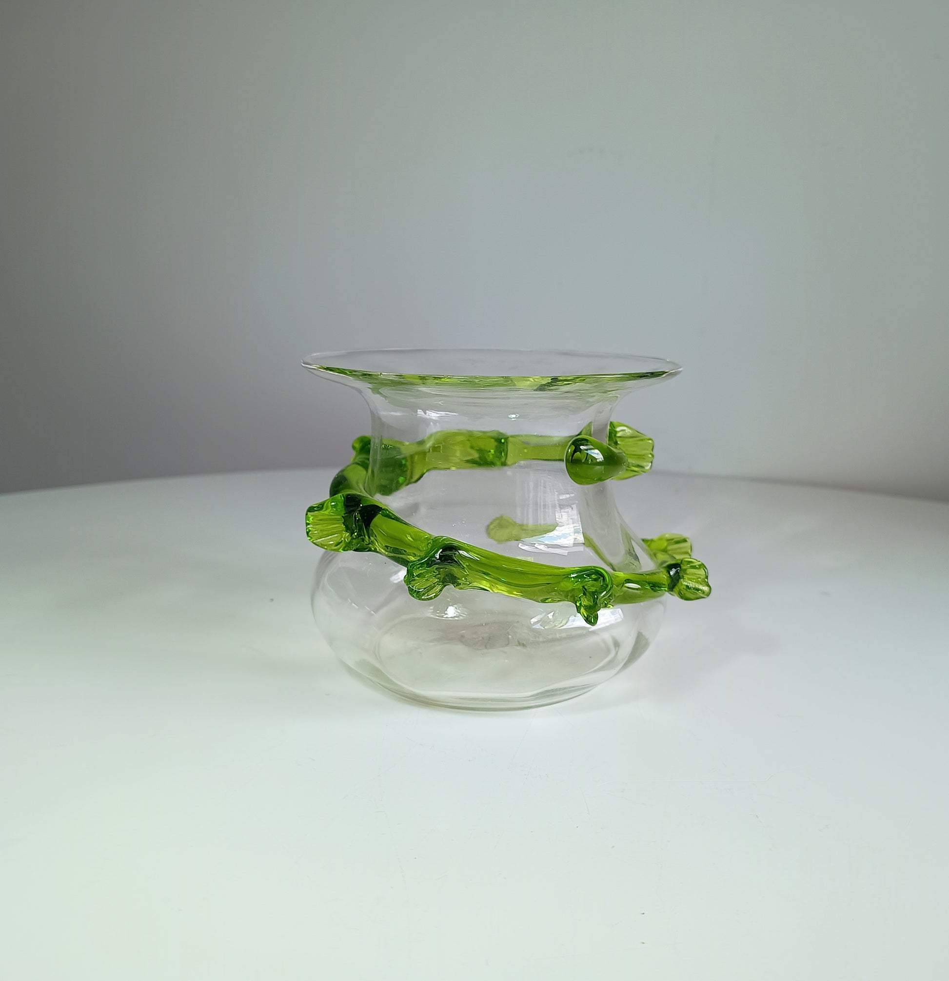 Art Nouveau Vintage Clear glass vase with green decorative elements on a white surface