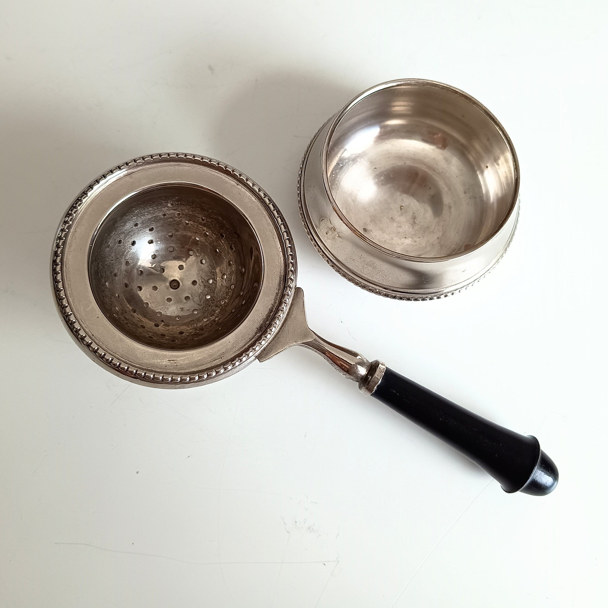 Silver tea strainer with black handle two part strainer