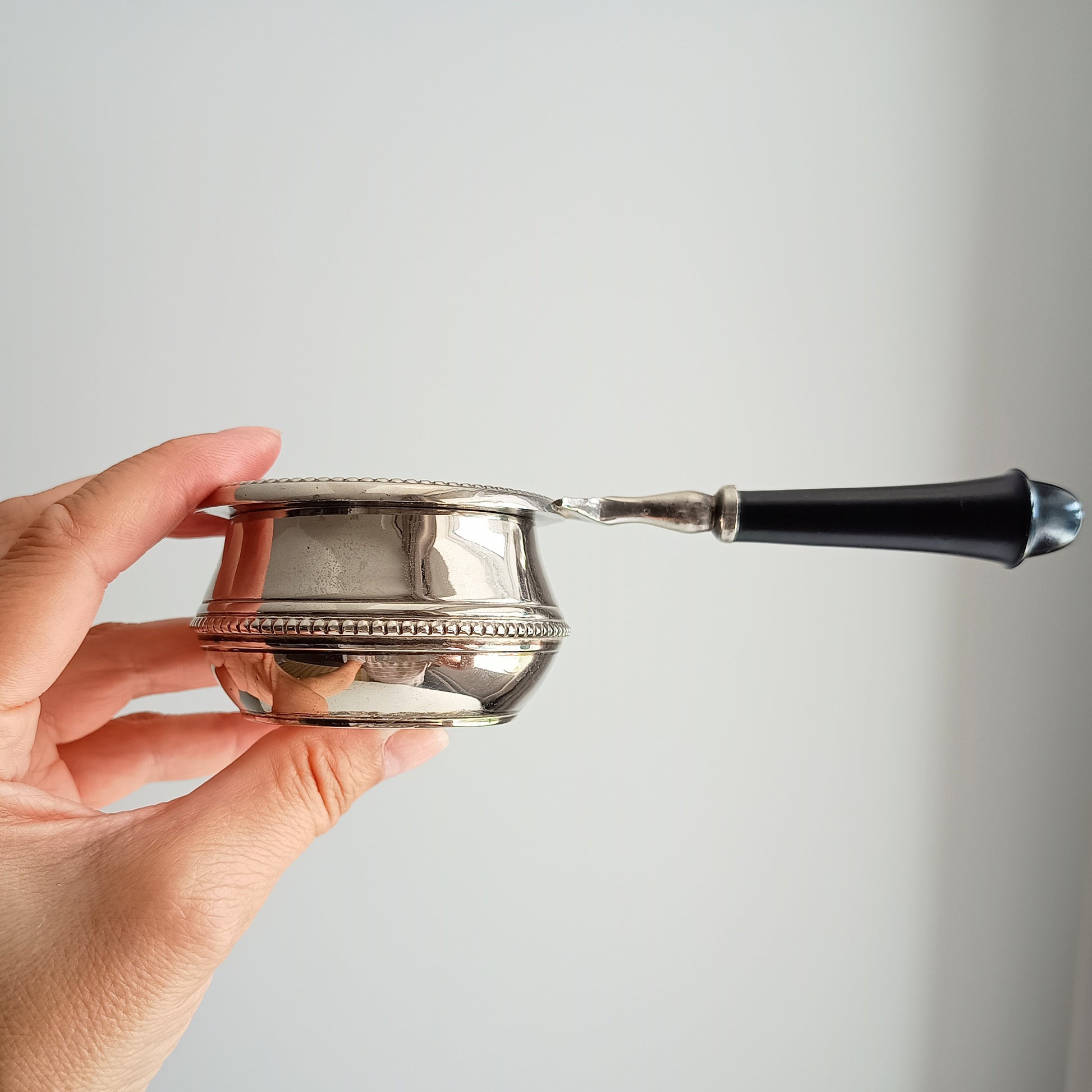 Vintage tea strainer with a black handle